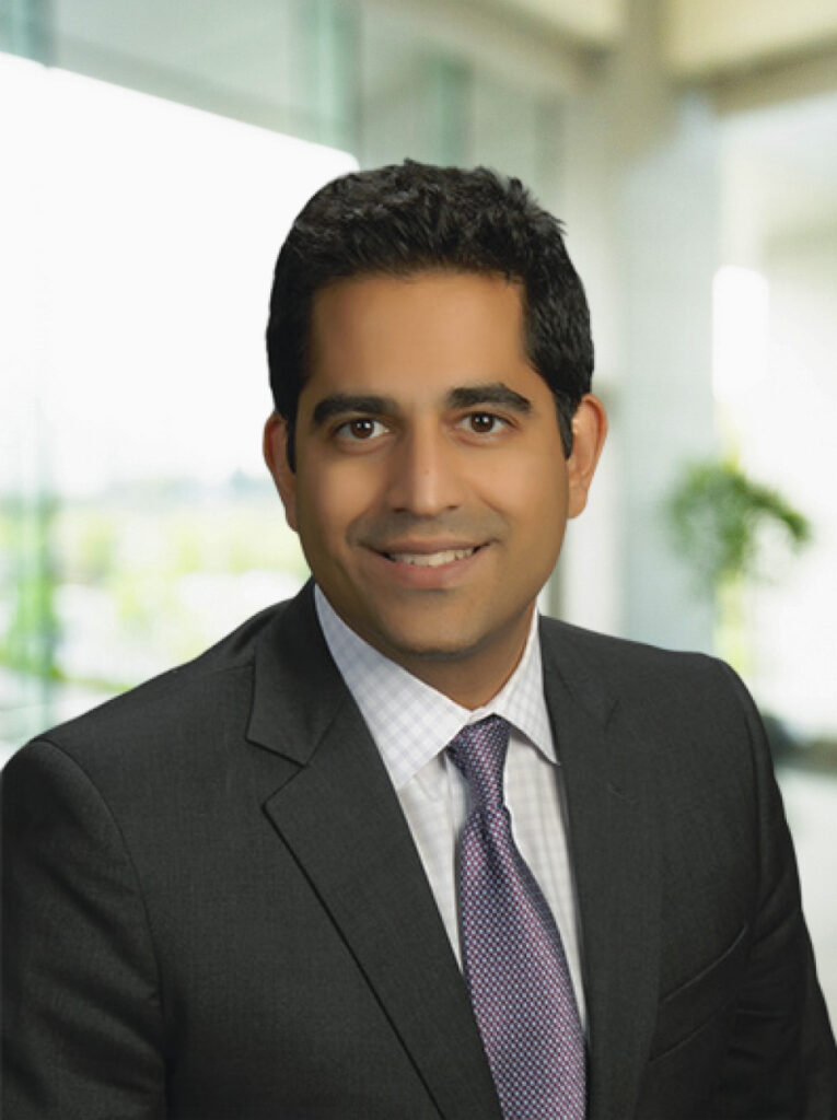 Deepak Sharma Attorney Portrait Professional attorney portrait in a business suit smiling in an office environment